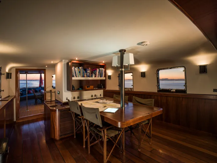 La Fenice Yacht Photos Pics Luxurious 1962 Richard Ironworks yacht interior with wooden dining area and ocean view.