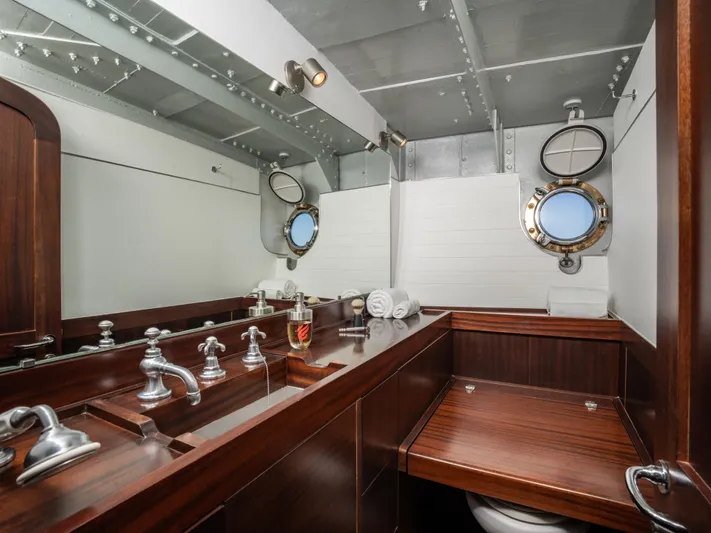 La Fenice Yacht Photos Pics Vintage 1962 Richard Ironworks bathroom with wooden cabinetry and nautical porthole windows.