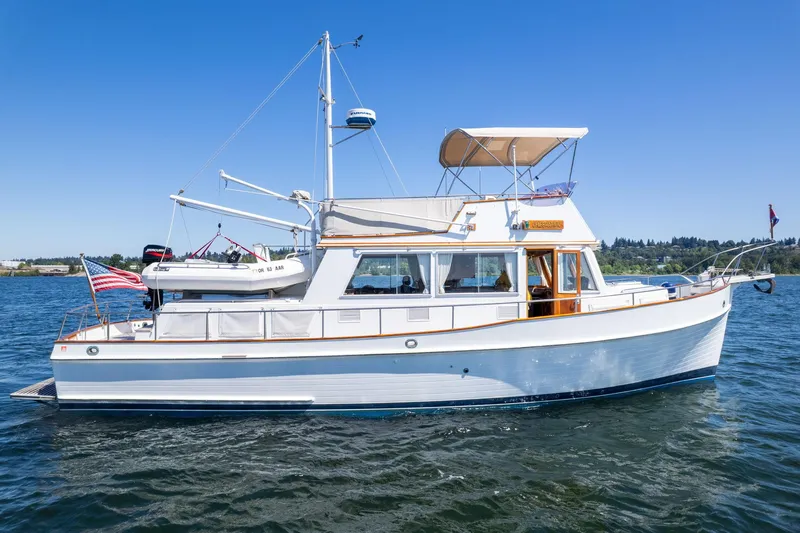 Celebration Yacht Photos Pics 1988 Grand Banks 42 Classic yacht on water, featuring elegant design and American flag.