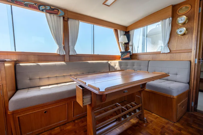 Celebration Yacht Photos Pics Interior of 1988 Grand Banks 42 Classic yacht with wooden table and cushioned seating.