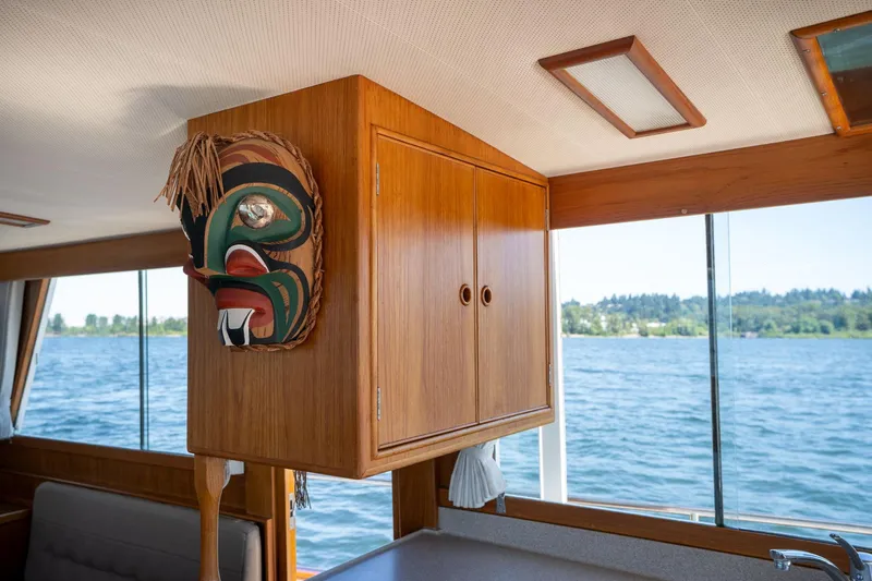 Celebration Yacht Photos Pics Interior of 1988 Grand Banks 42 Classic yacht with wooden cabinetry and decorative mask.