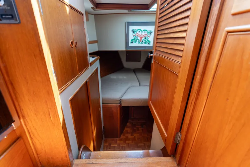 Celebration Yacht Photos Pics 1988 Grand Banks 42 Classic cabin interior with wooden finish and cozy sleeping area.
