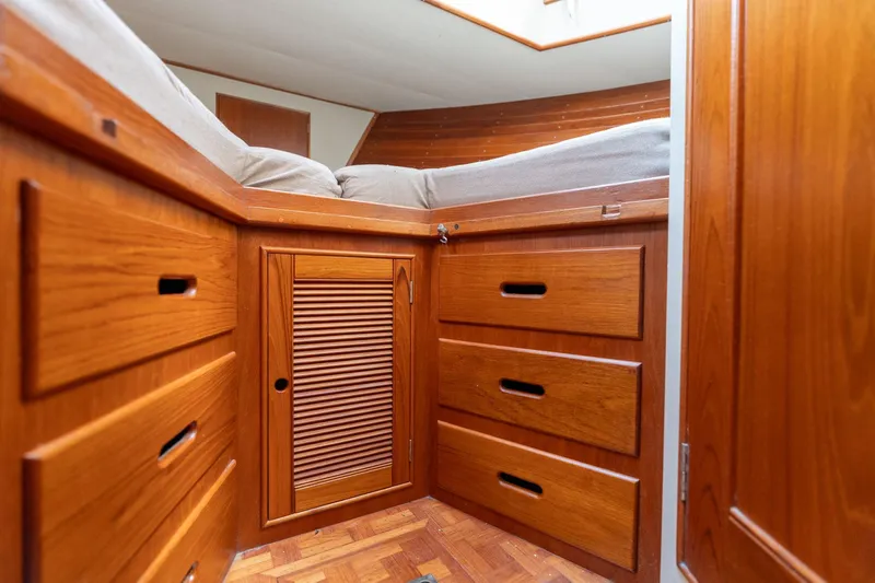 Celebration Yacht Photos Pics Cozy cabin interior of 1988 Grand Banks 42 Classic with wooden drawers and bed.