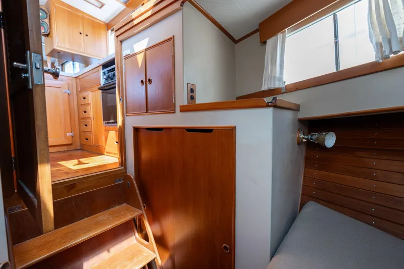 Celebration Yacht Photos Pics Interior of 1988 Grand Banks 42 Classic yacht, featuring wooden cabinetry and cozy seating area.
