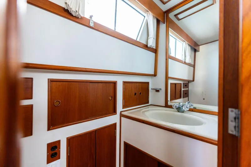 Celebration Yacht Photos Pics Interior of 1988 Grand Banks 42 Classic yacht bathroom with wooden cabinetry and sink.