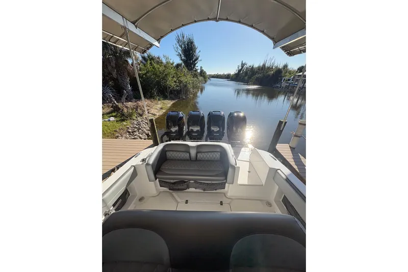  Yacht Photos Pics 2017 Nor-Tech 390 Sport Center Console boat docked by a serene river.