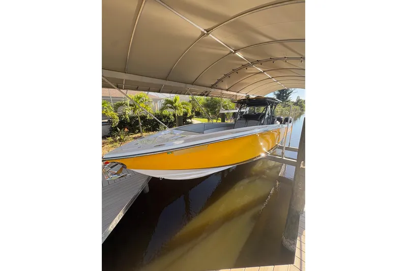  Yacht Photos Pics 2017 Nor-Tech 390 Sport Center Console boat in yellow, docked under a canopy.