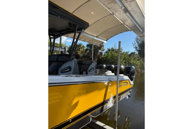  Yacht Photos Pics 2017 Nor-Tech 390 Sport Center Console boat with yellow hull, docked under canopy.
