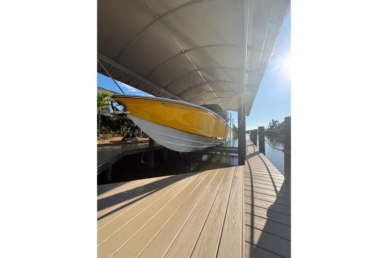  Yacht Photos Pics 2017 Nor-Tech 390 Sport Center Console in yellow, docked under a canopy.