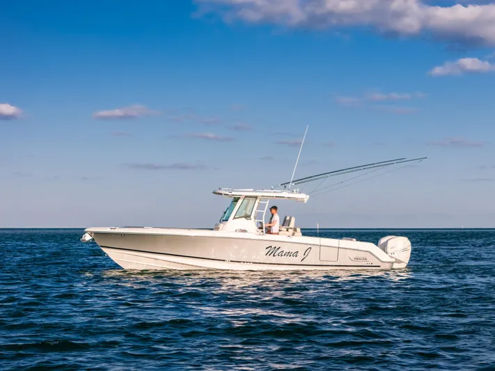 Mama J Yacht Photos Pics 2021 Boston Whaler 330 Outrage boat on open water under blue sky.
