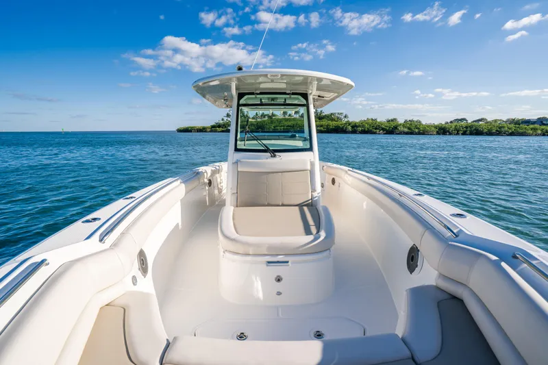 Mama J Yacht Photos Pics 2021 Boston Whaler 330 Outrage boat on calm water, clear sky background.