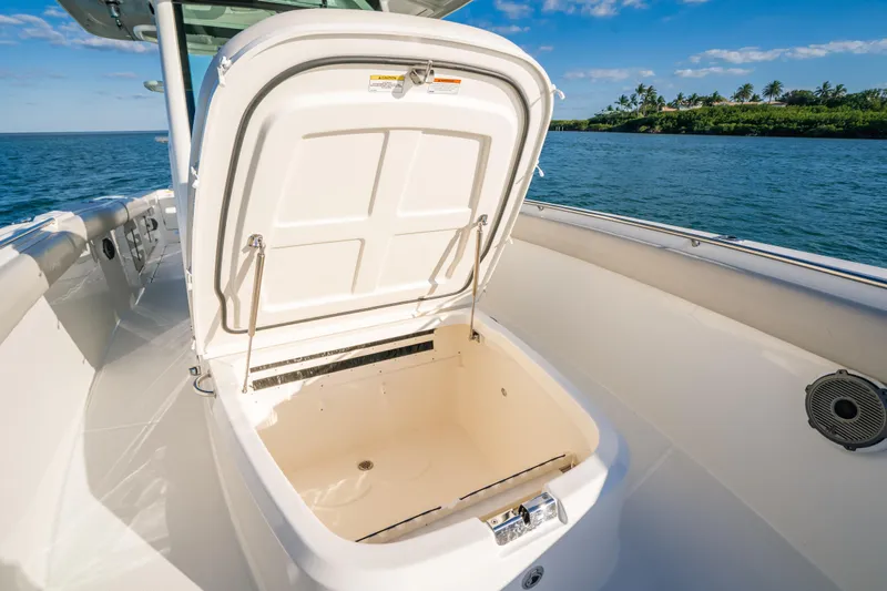 Mama J Yacht Photos Pics 2021 Boston Whaler 330 Outrage boat with open storage compartment, ocean view.
