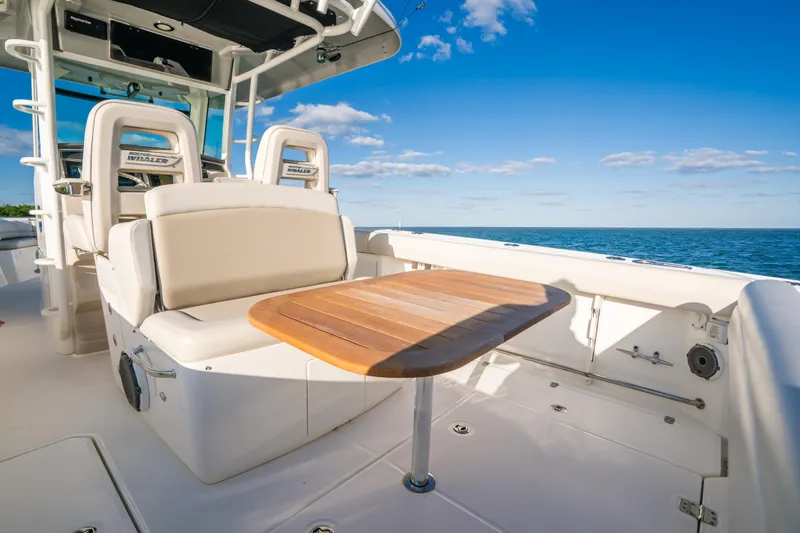 Mama J Yacht Photos Pics Boston Whaler 330 Outrage 2021 boat interior with seating and wooden table, ocean view.