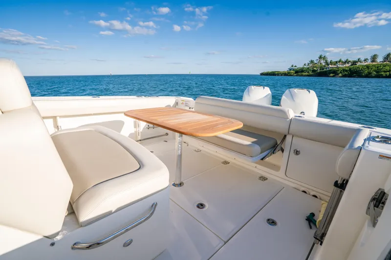 Mama J Yacht Photos Pics 2021 Boston Whaler 330 Outrage boat interior with seating and table, ocean view.
