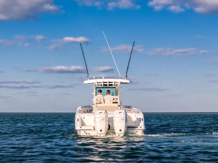 Mama J Yacht Photos Pics 2021 Boston Whaler 330 Outrage boat cruising on open water under blue sky.