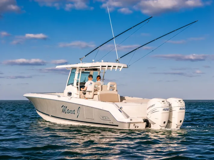 Mama J Yacht Photos Pics 2021 Boston Whaler 330 Outrage boat on open water, featuring dual Mercury engines.