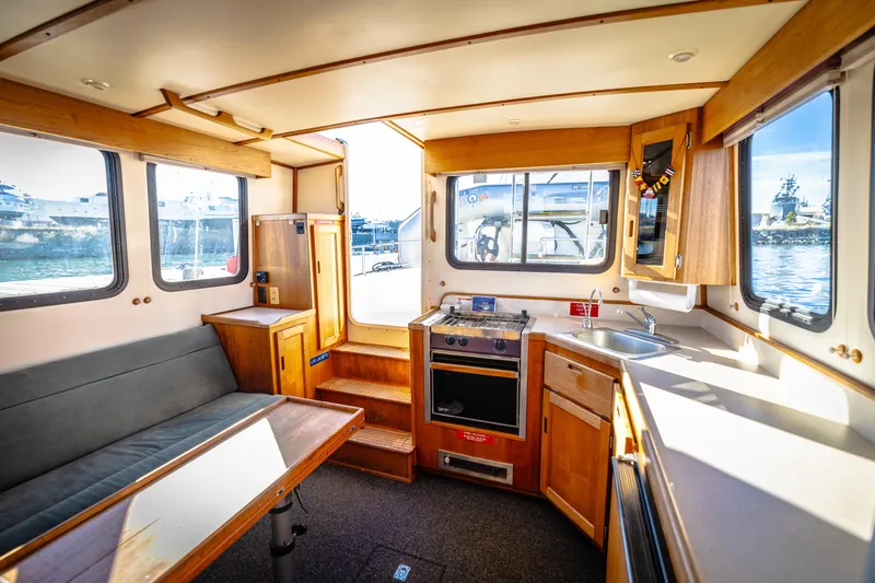 Old Bro Yacht Photos Pics Interior of a 2001 Nordic Tug 32, featuring a cozy kitchen and seating area.
