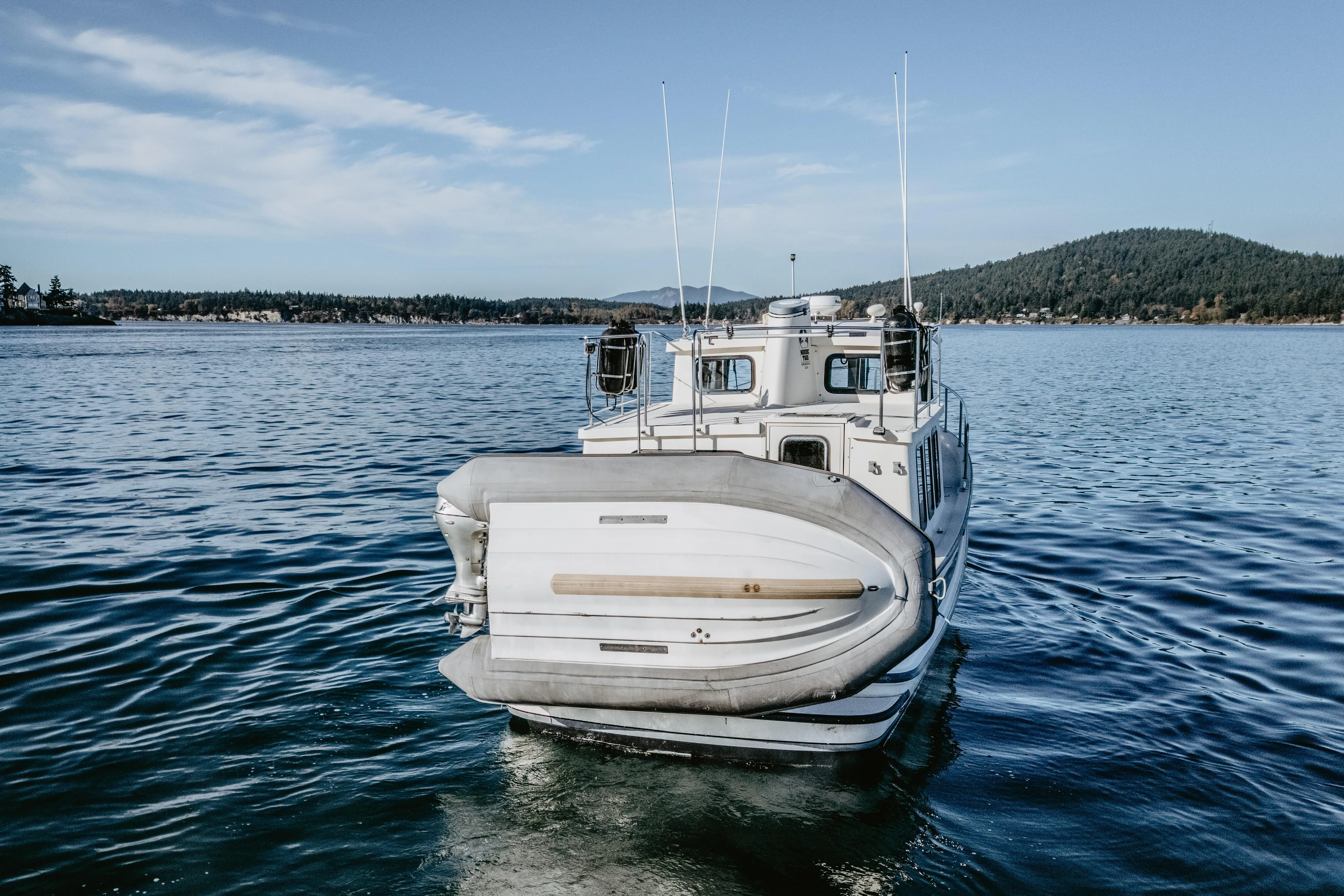 Old Bro Yacht Photos Pics 2001 Nordic Tug 32 on calm water with scenic background.