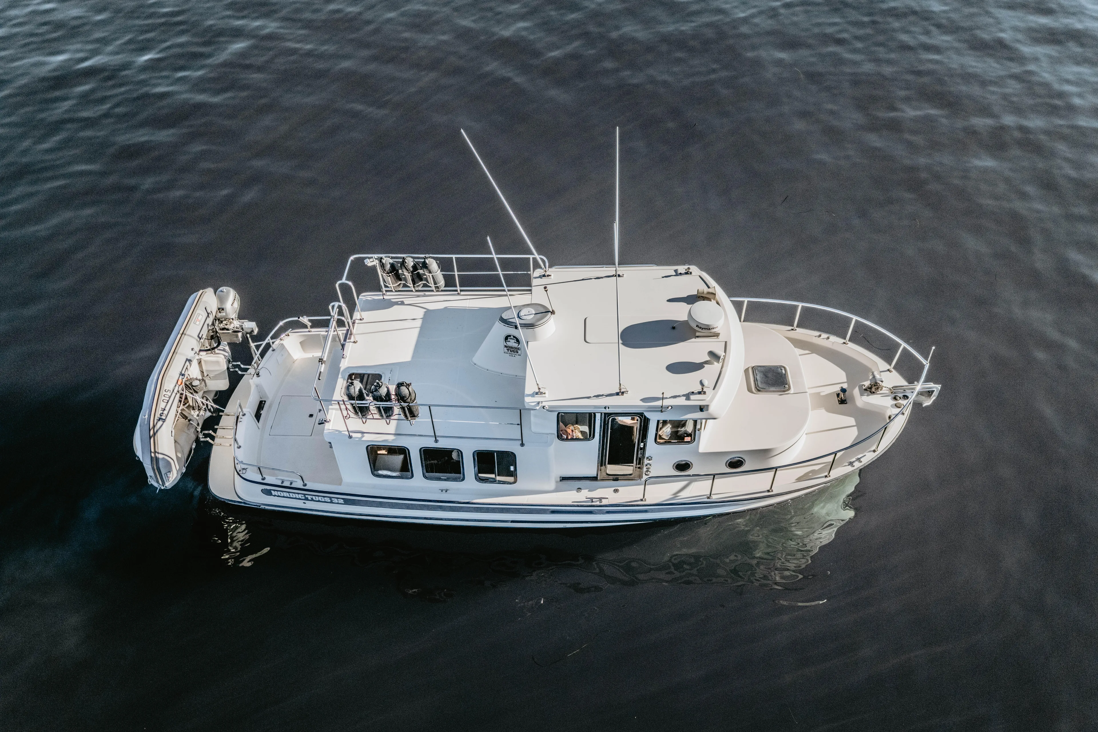 Old Bro Yacht Photos Pics Nordic Tug 32, 2001 model, cruising on calm waters, aerial view.