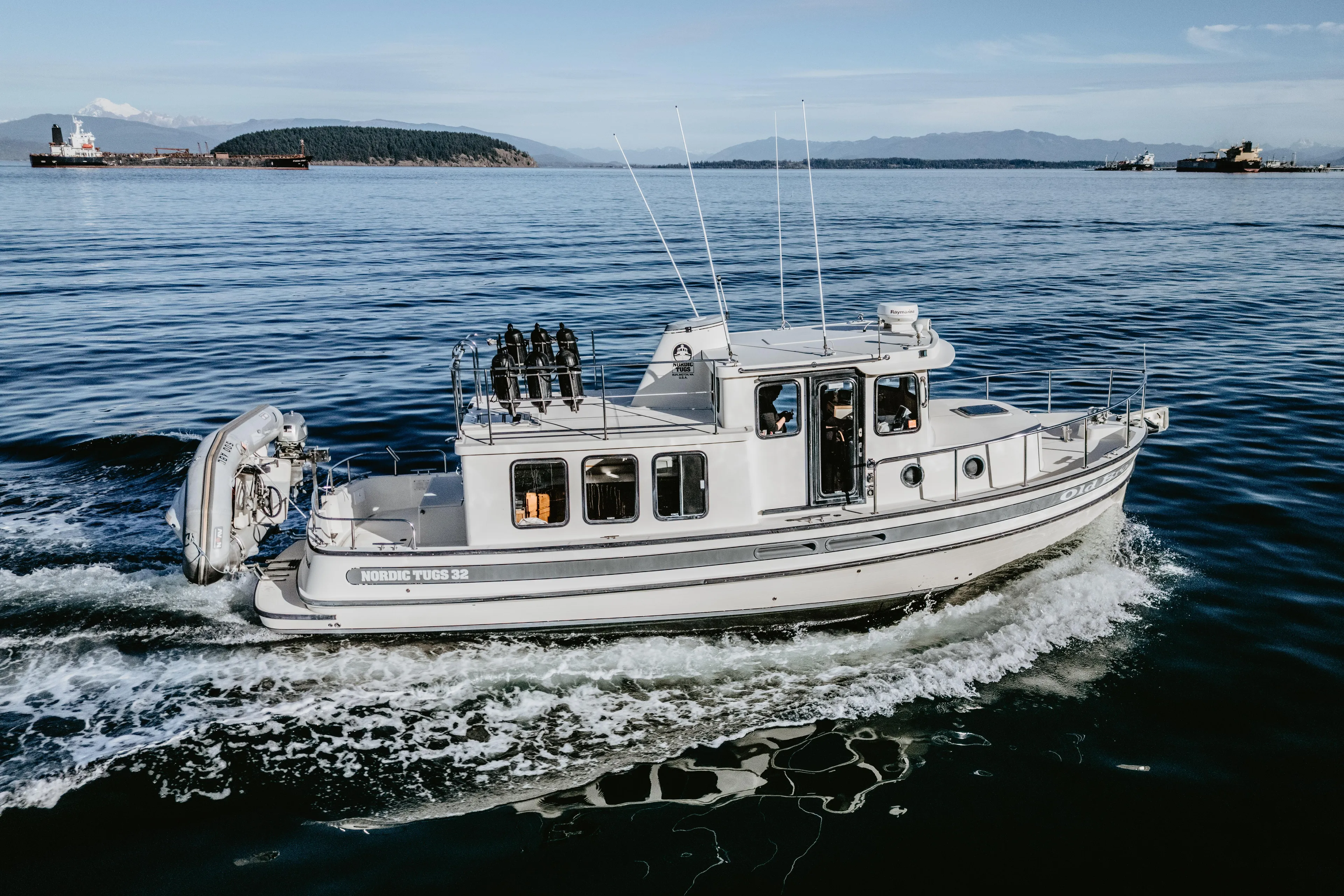 Old Bro Yacht Photos Pics 2001 Nordic Tug 32 cruising on calm waters with scenic background.