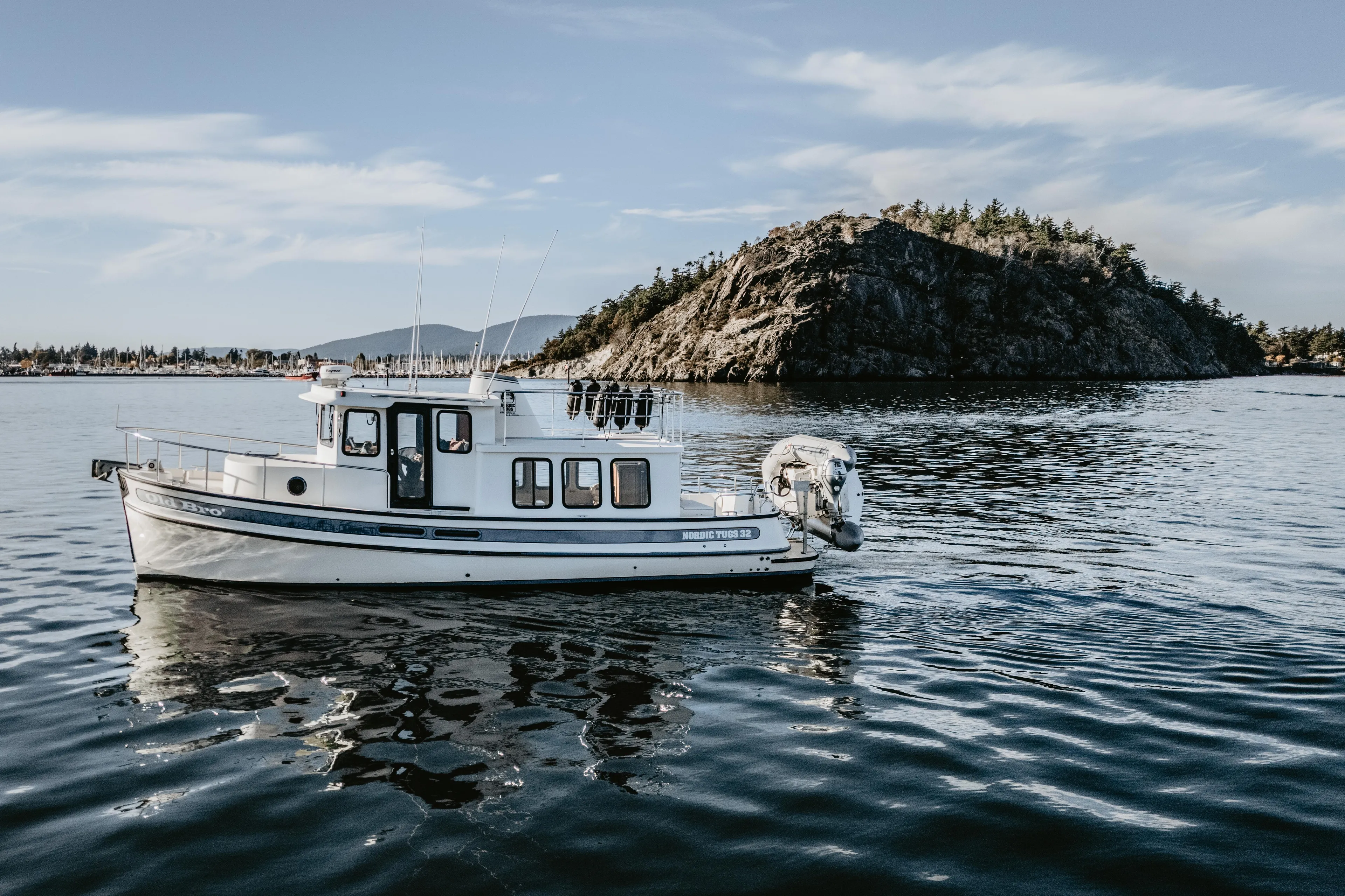 Old Bro Yacht Photos Pics 2001 Nordic Tug 32 boat on calm water with rocky island background.