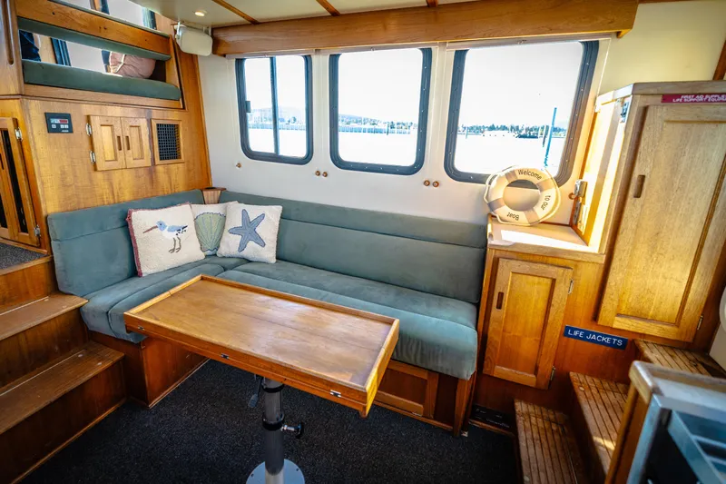 Old Bro Yacht Photos Pics Cozy interior of 2001 Nordic Tug 32 with wooden furnishings and nautical decor.