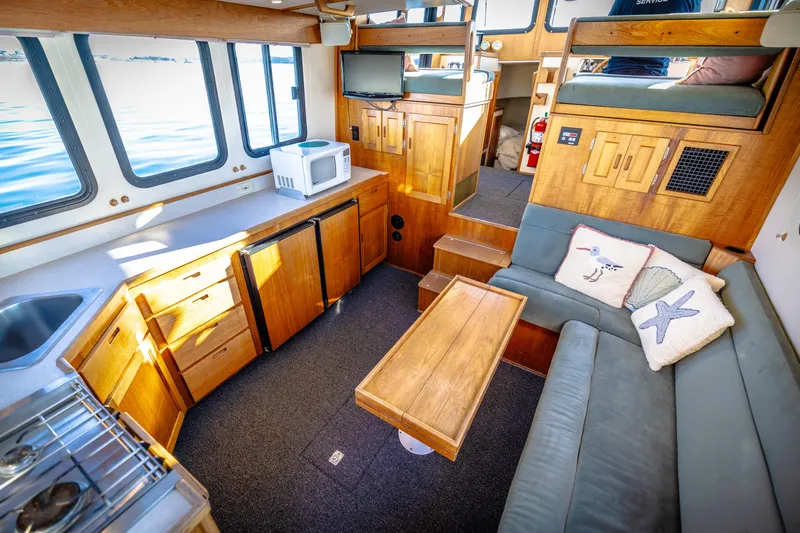 Old Bro Yacht Photos Pics Interior of 2001 Nordic Tug 32 with cozy seating, kitchenette, and nautical decor.