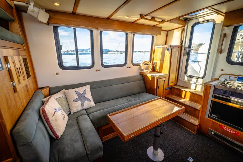Old Bro Yacht Photos Pics Cozy interior of a 2001 Nordic Tug 32 with seating, table, and nautical decor.