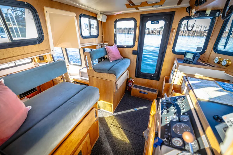Old Bro Yacht Photos Pics Interior of a 2001 Nordic Tug 32, featuring cozy seating and navigational equipment.