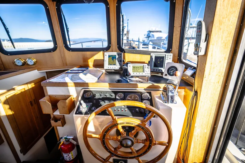 Old Bro Yacht Photos Pics Pilothouse of a 2001 Nordic Tug 32 with navigation equipment and wooden steering wheel.