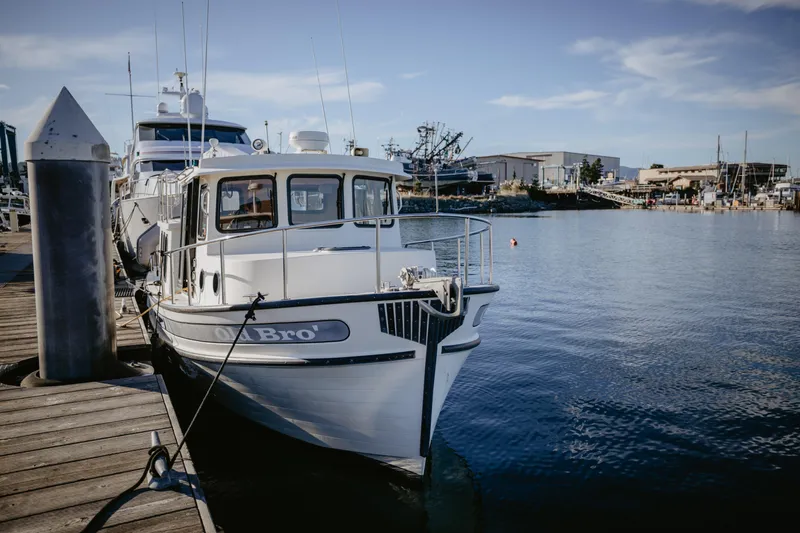 Old Bro Yacht Photos Pics 2001 Nordic Tug 32 docked at a marina, clear sky, calm water.