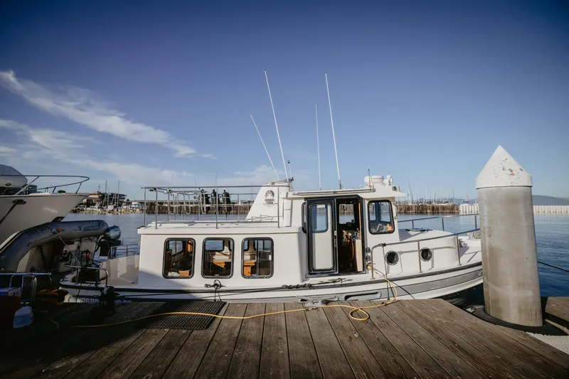 Old Bro Yacht Photos Pics 2001 Nordic Tug 32 docked at marina under clear blue sky.