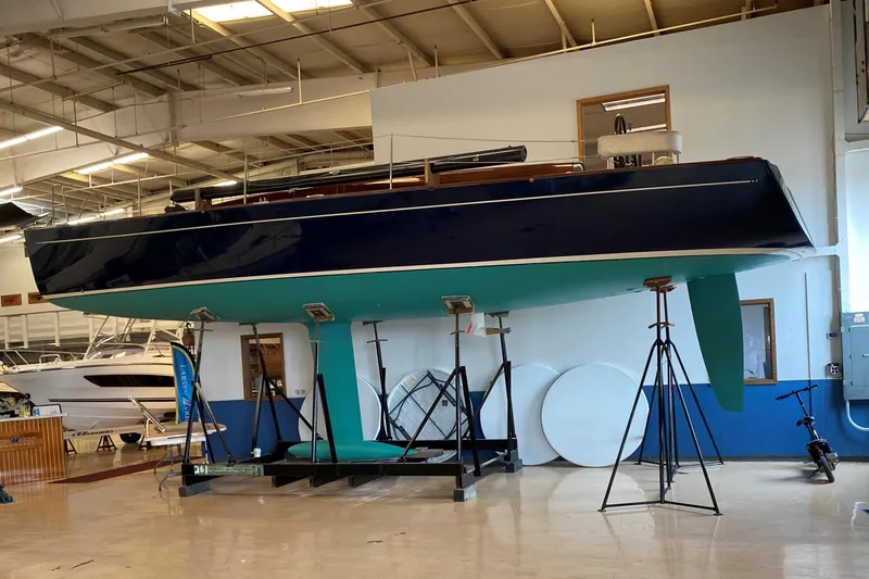 Blue Star Yacht Photos Pics 2018 Tofinou 12 sailboat displayed indoors on stands, showcasing sleek design and craftsmanship.