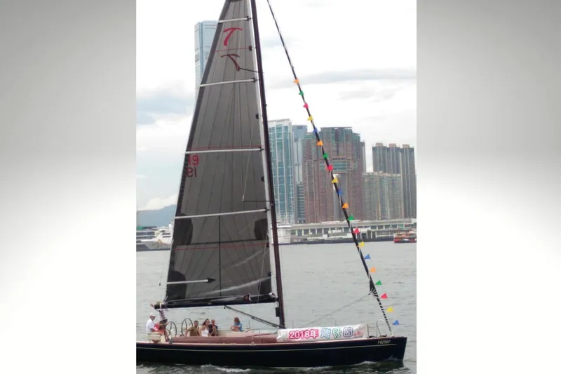 Blue Star Yacht Photos Pics 2018 Tofinou 12 sailboat on water with city skyline in background.