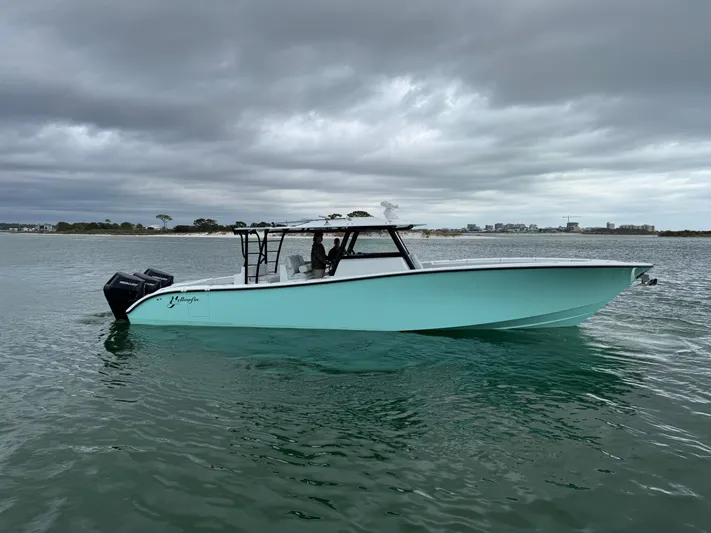  Yacht Photos Pics 2023 Yellowfin 42 Offshore boat on calm water under cloudy skies.