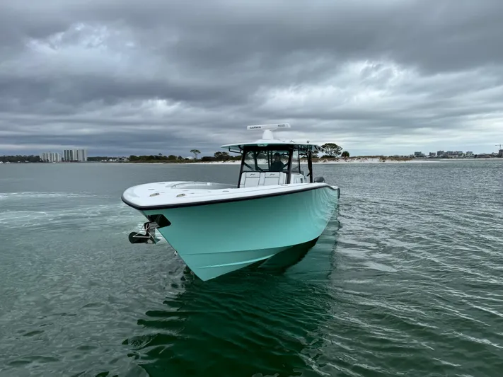  Yacht Photos Pics 2023 Yellowfin 42 Offshore boat on calm water under cloudy skies.