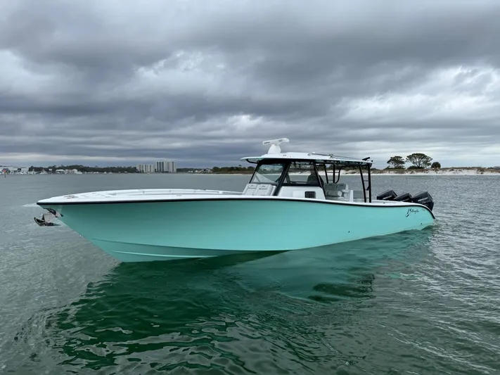  Yacht Photos Pics 2023 Yellowfin 42 Offshore boat on calm water under cloudy skies.