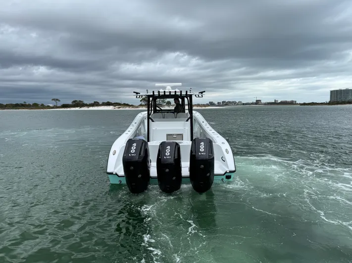  Yacht Photos Pics 2023 Yellowfin 42 Offshore boat with triple engines on open water.