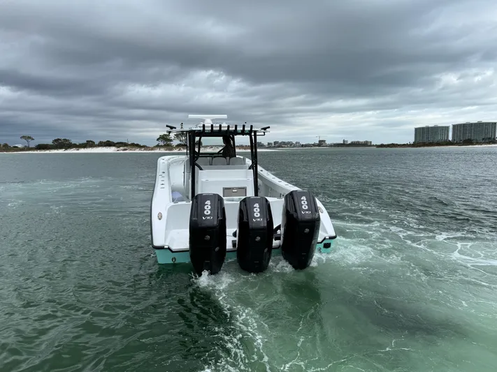  Yacht Photos Pics 2023 Yellowfin 42 Offshore boat with triple outboard engines on water.