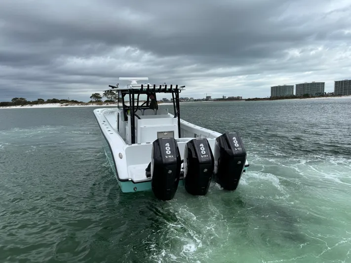  Yacht Photos Pics 2023 Yellowfin 42 Offshore boat with triple engines on a cloudy day.