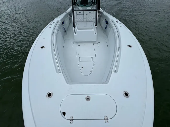  Yacht Photos Pics 2023 Yellowfin 42 Offshore boat, spacious deck, sleek design, on calm water.