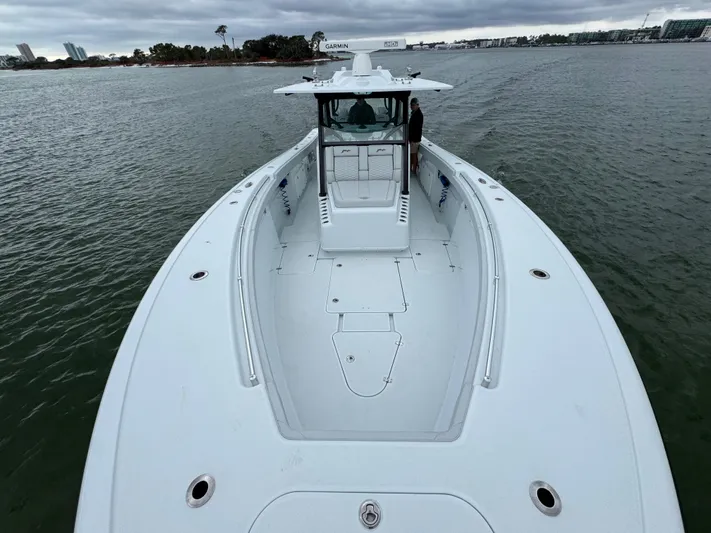  Yacht Photos Pics 2023 Yellowfin 42 Offshore boat on calm water, showcasing spacious deck design.