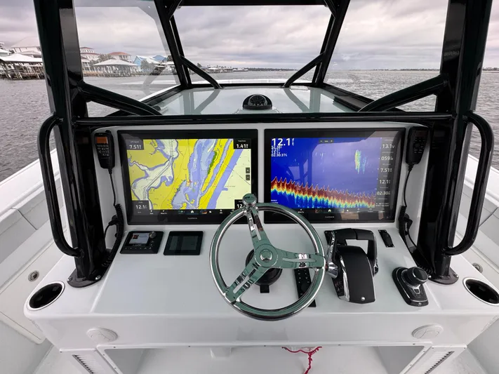  Yacht Photos Pics 2023 Yellowfin 42 Offshore boat dashboard with navigation screens and steering wheel.