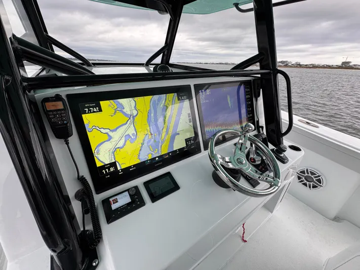  Yacht Photos Pics 2023 Yellowfin 42 Offshore boat dashboard with navigation screens and steering wheel.