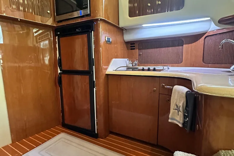 August Moon Yacht Photos Pics Luxurious 2001 Sea Ray 400 Sedan Bridge yacht kitchen with wood cabinetry and modern appliances.