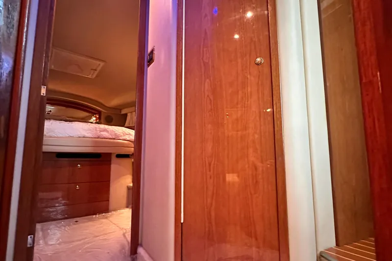 August Moon Yacht Photos Pics Interior cabin view of 2001 Sea Ray 400 Sedan Bridge yacht, featuring wood paneling and cozy bedding.