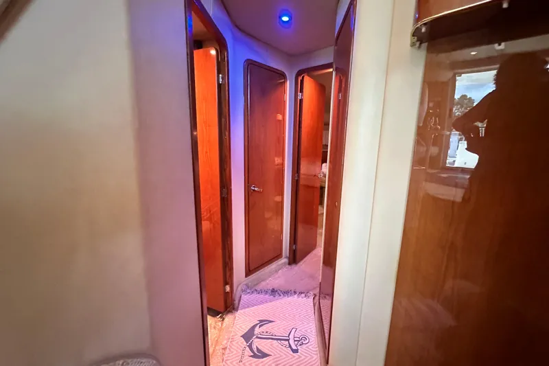 August Moon Yacht Photos Pics Interior hallway of 2001 Sea Ray 400 Sedan Bridge yacht with wooden doors and blue lighting.