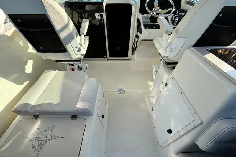  Yacht Photos Pics 2006 Pursuit 3070 Offshore boat interior with white seating and steering area.