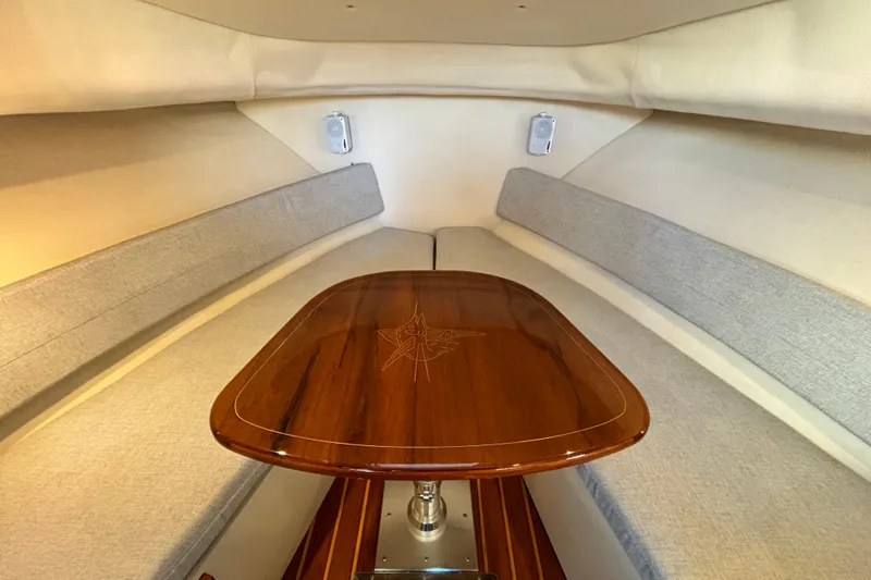  Yacht Photos Pics Interior of 2006 Pursuit 3070 Offshore boat with elegant wood table and cushioned seating.