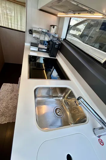  Yacht Photos Pics Modern kitchen in 2023 Azimut Fly 60 yacht with sleek appliances and stainless steel sink.